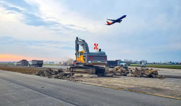 A Southwest Airlines Boeing 737 soars above construction equipment during the morning hours in Columbus, Ohio.